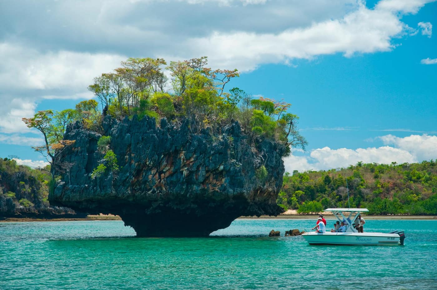 Boat moored near a limestone islet sculpted by the sea