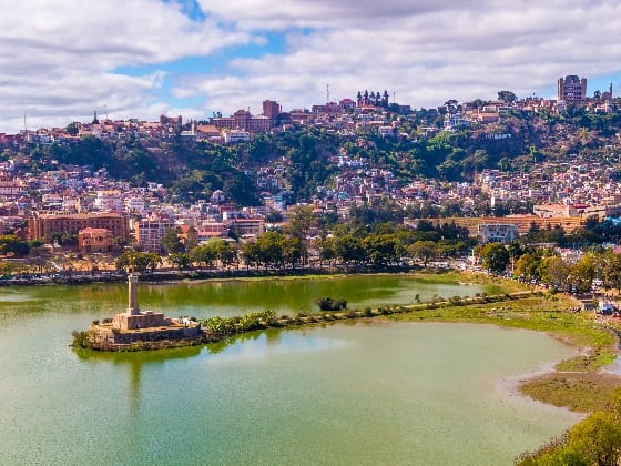 Lake Anosy and its monument on a small island, below the hillside upper town of Antananarivo.