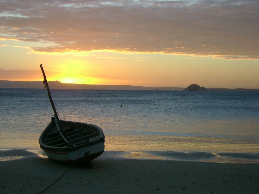 Fishing canoe pulled up on the beach at sunset, northern Madagascar
