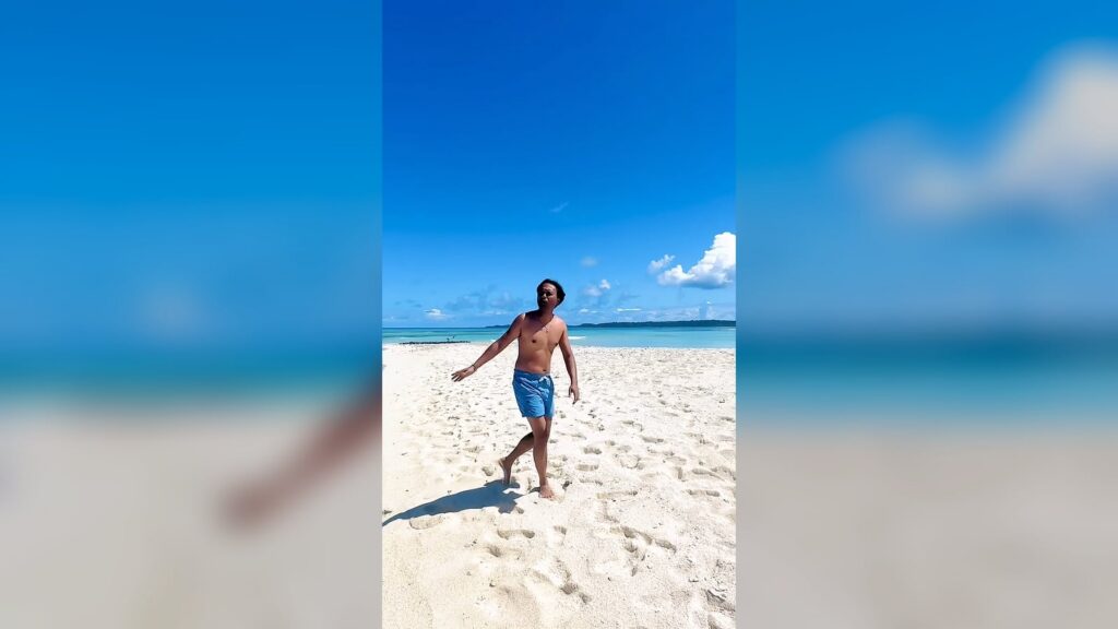 Our CEO on the white sandbank of Île aux Sables, facing the turquoise lagoon