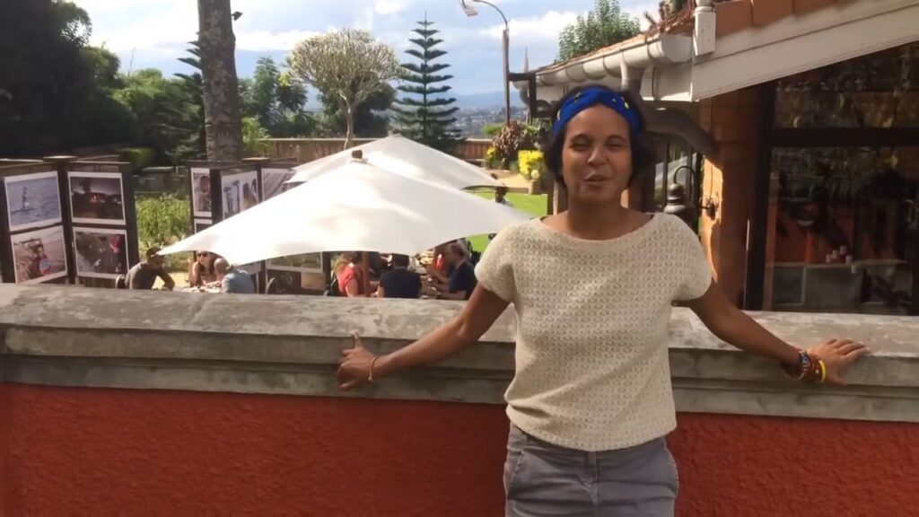 A traveller shares her experience on video, on a garden terrace in bloom