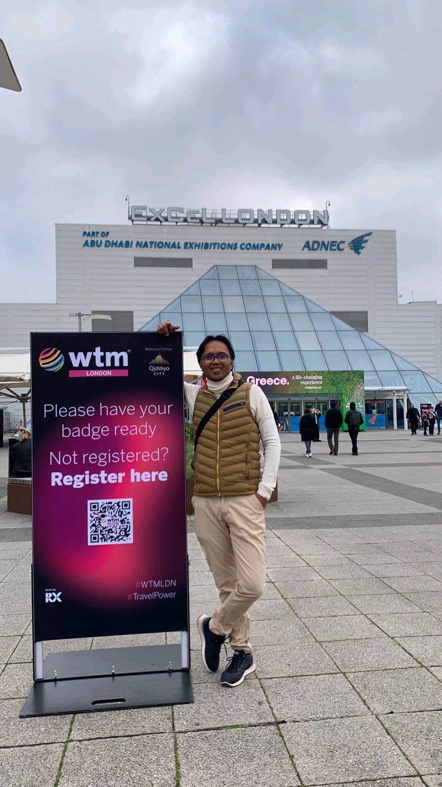A member of the Bemiray Tours team outside ExCeL London, next to the WTM London welcome sign